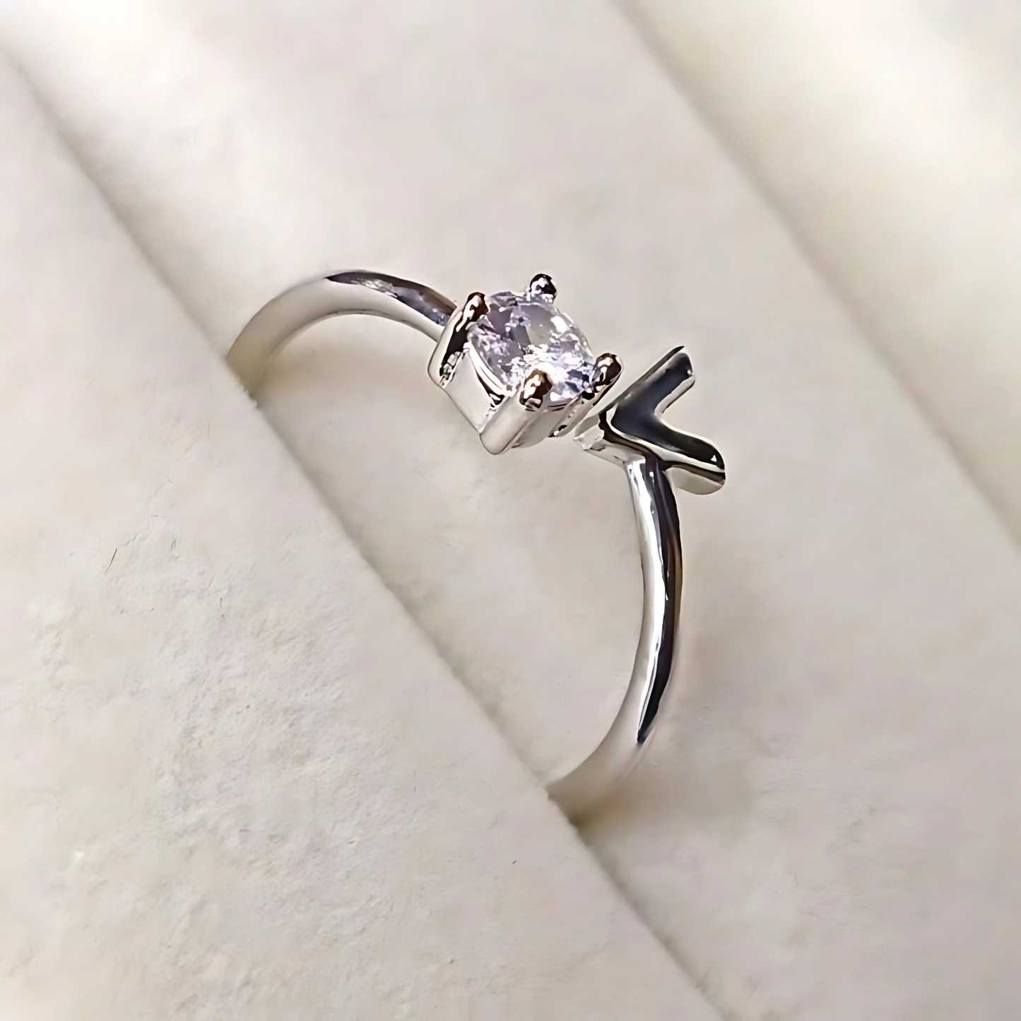 Silver ring with a gemstone on a soft beige background