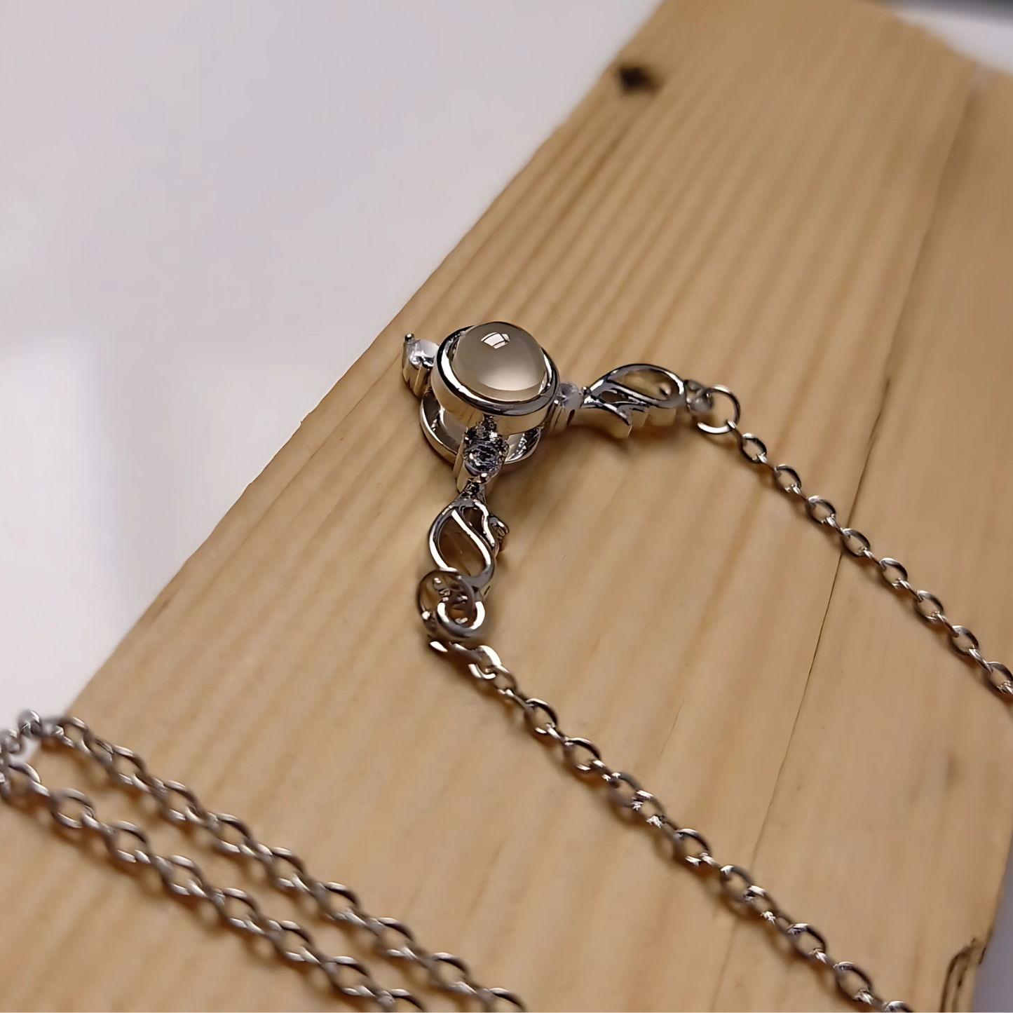 Silver bracelet with a round gemstone on a wooden surface