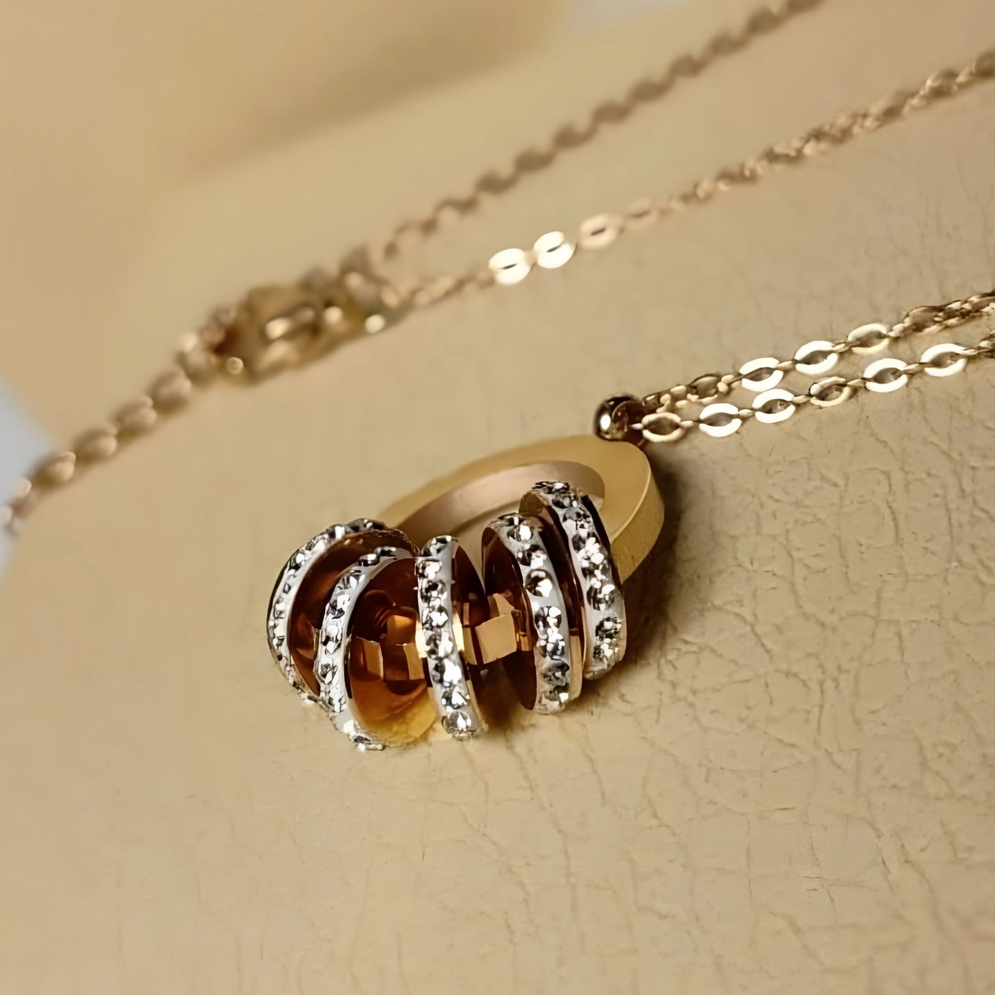 Gold necklace with a pendant on a beige background