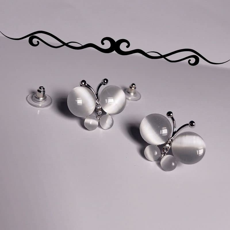 Butterfly-shaped earrings with white and silver details on a light gray background