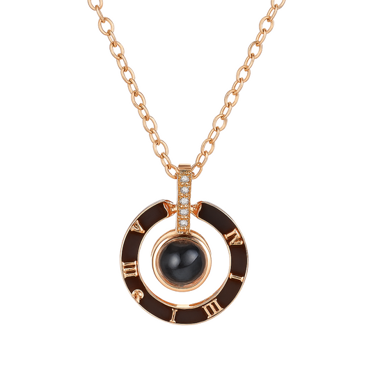 Rose gold necklace with black pendant and Roman numeral design on a white background