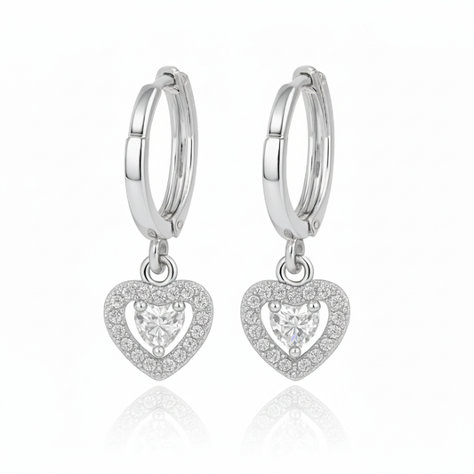 Silver hoop earrings with heart-shaped pendants on a white background