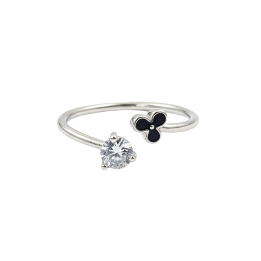 Silver ring with a heart-shaped gemstone and clover charm on a white background