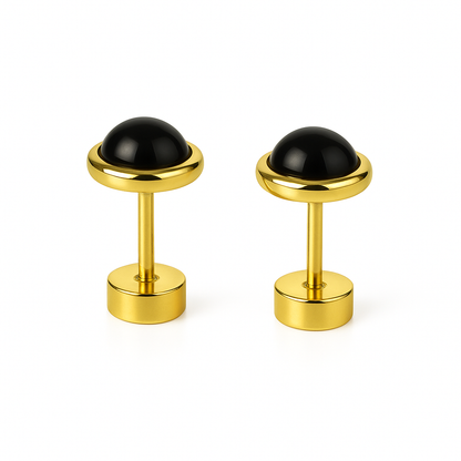 Pair of gold cufflinks with black dome stones on a white background