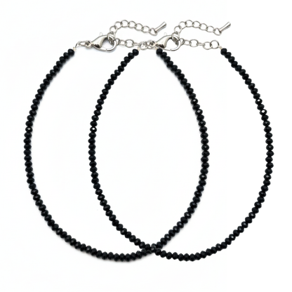 Two black beaded necklaces on a white background