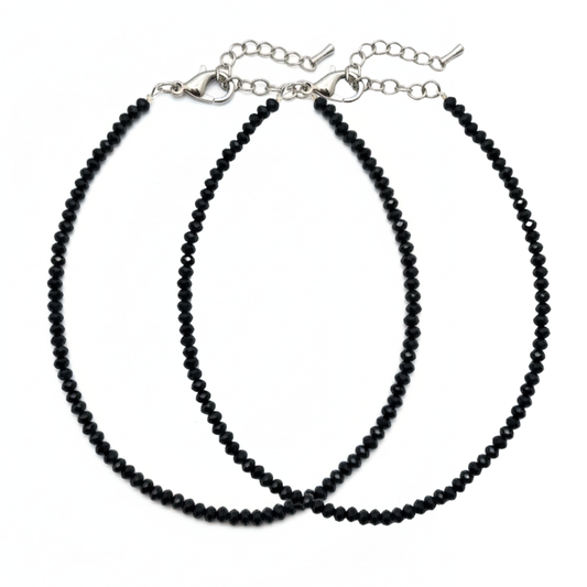 Two black beaded necklaces on a white background