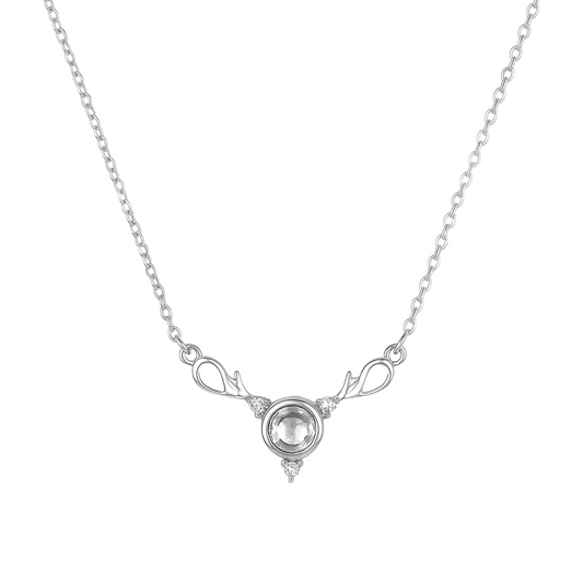 Silver necklace with a clear gemstone on a white background