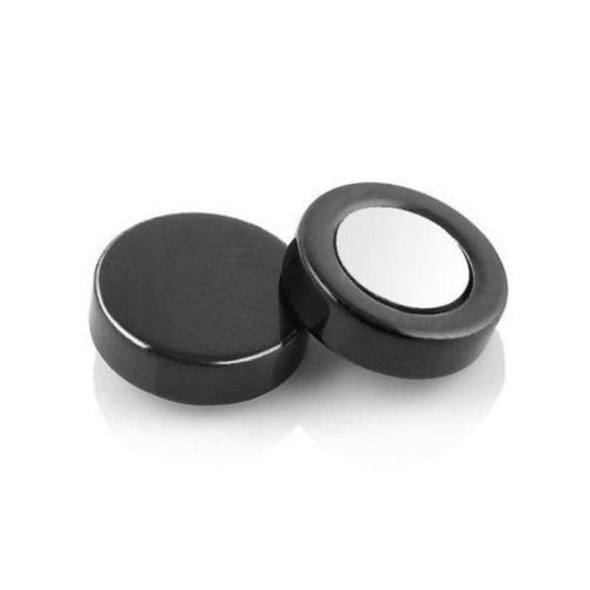 Two black circular objects with one having a metallic center on a white background