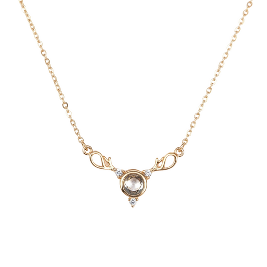 Gold necklace with a central gemstone on a white background