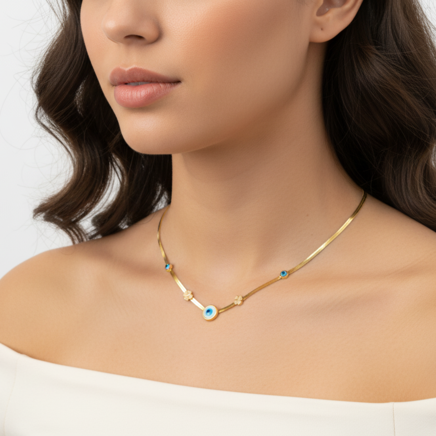 Close-up of a woman wearing a gold necklace with a blue pendant on a white background