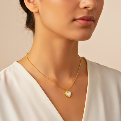 Woman wearing a gold necklace with a heart-shaped pendant on a beige background
