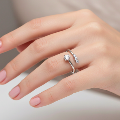 Hand wearing a silver ring with a diamond on a neutral background