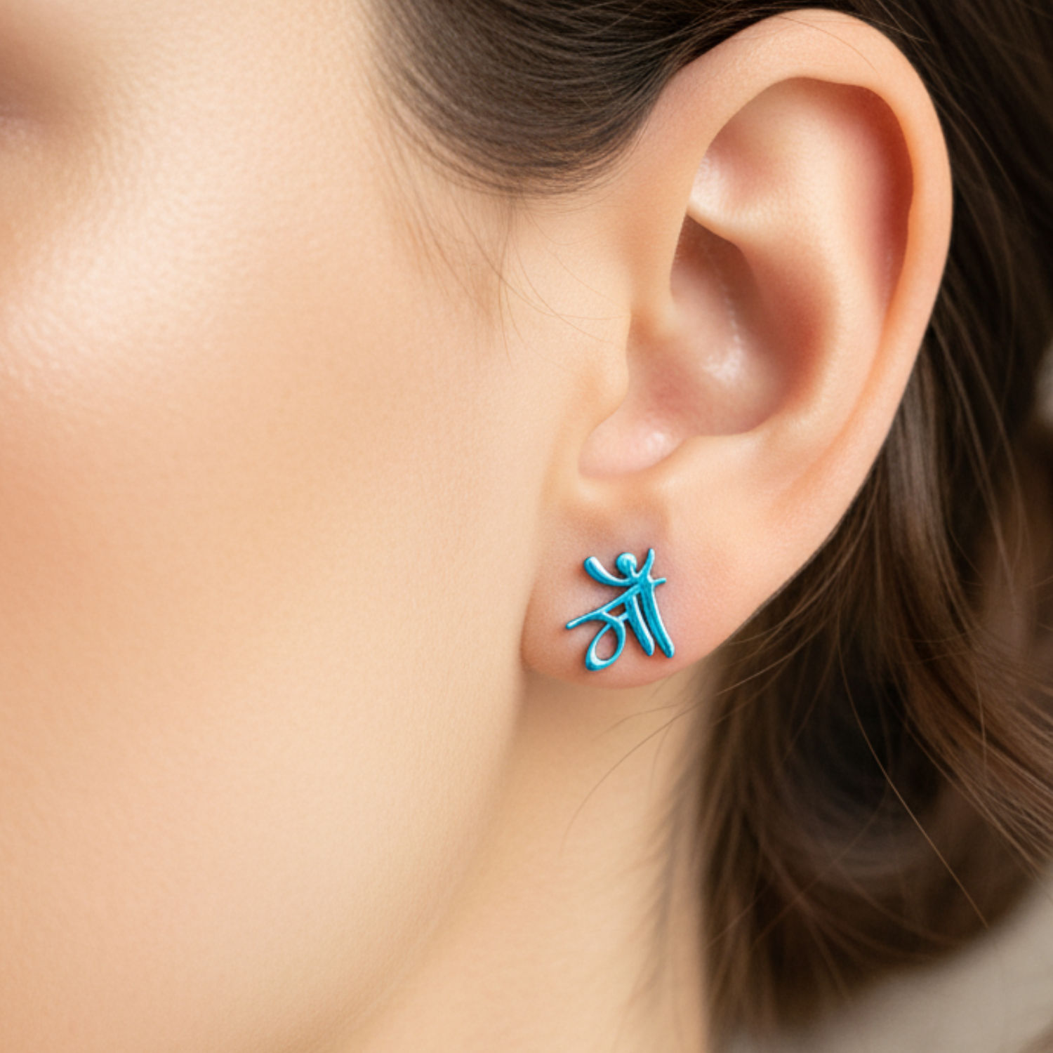 Close-up of an ear wearing a blue earring with a unique design.