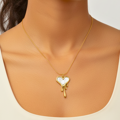 Gold necklace with a heart-shaped pendant on a neutral background