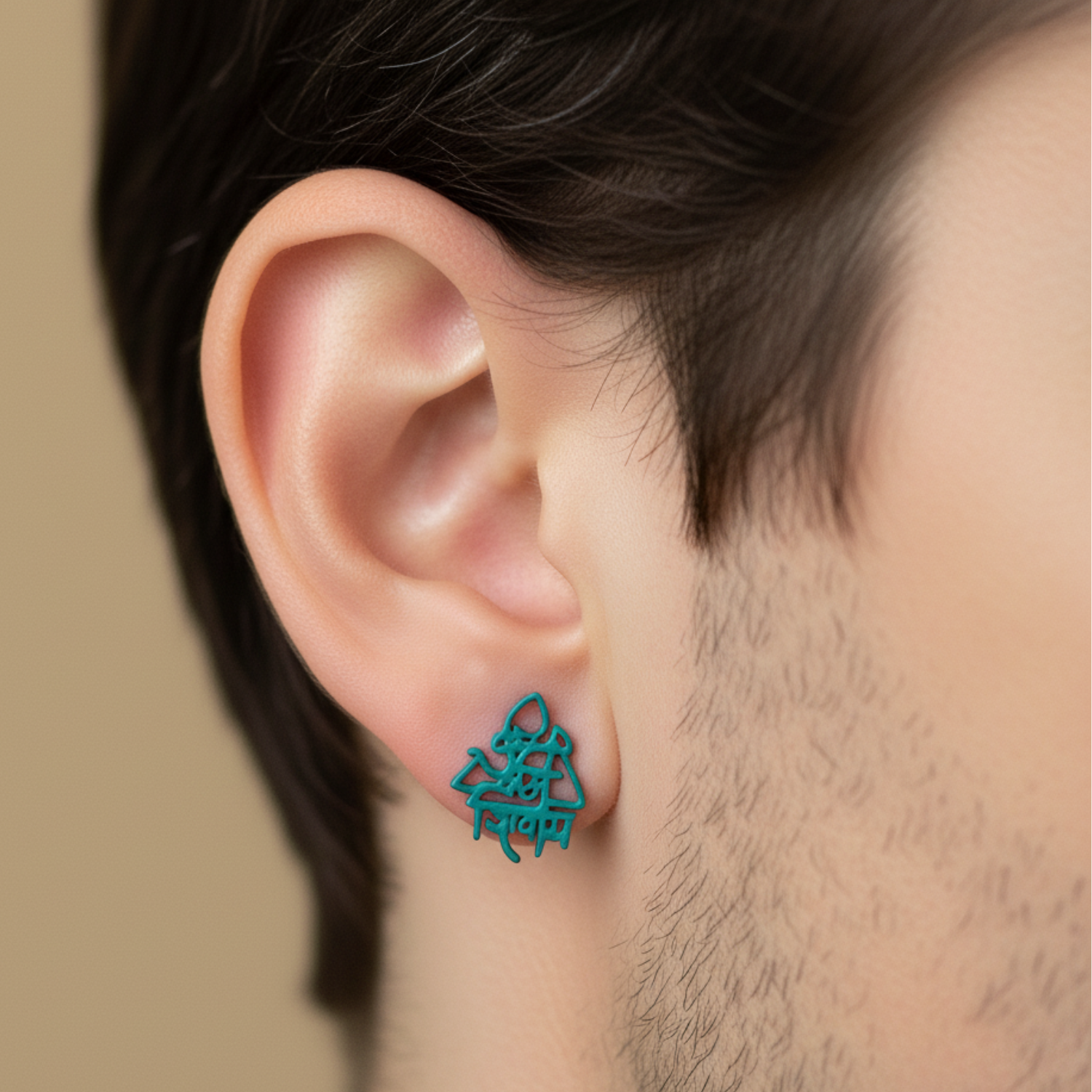 Close-up of an ear wearing a turquoise geometric earring against a neutral background