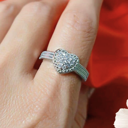 Silver ring with gemstones on a finger against a red background
