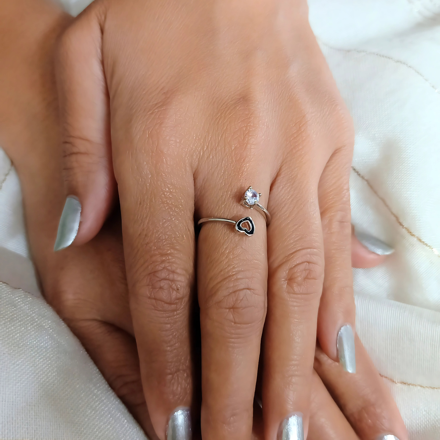Close-up of a hand wearing two rings on a light background