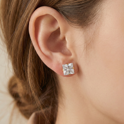 Close-up of an ear wearing a diamond earring with a blurred background