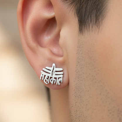 Silver stud earrings worn on an ear with a blurred background
