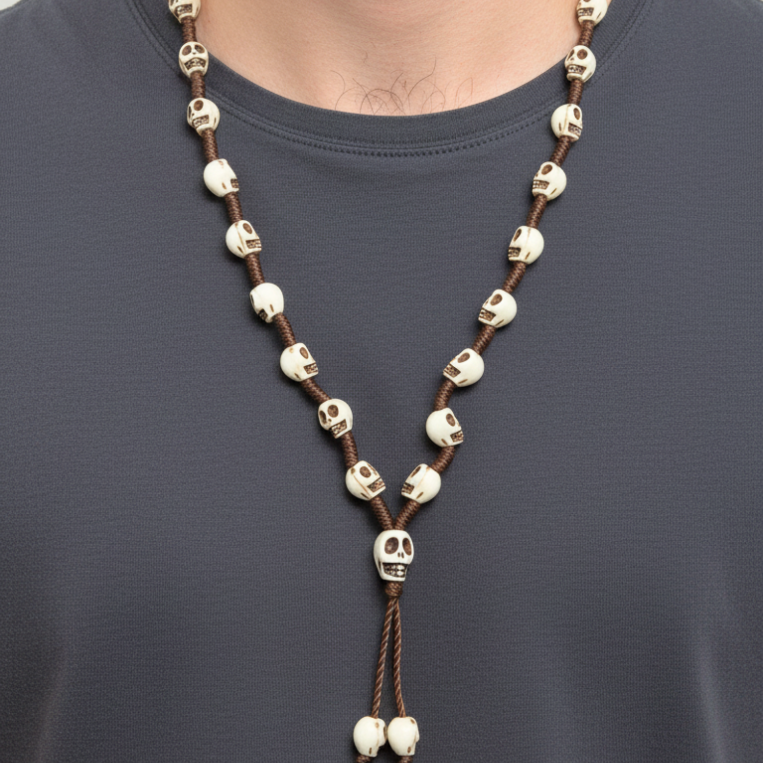 Skull-themed necklace on a person wearing a dark shirt