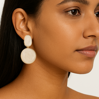 Close-up of a woman wearing beige earrings with a neutral background