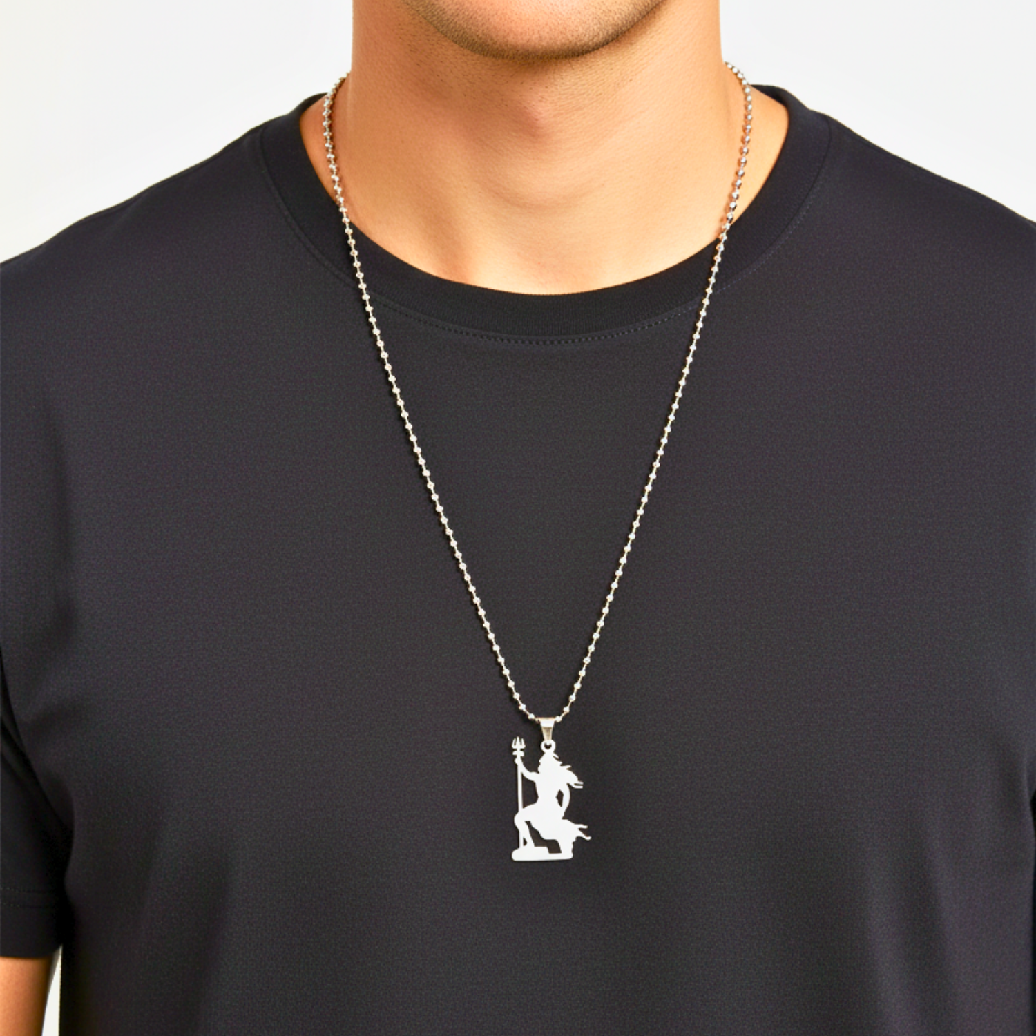Person wearing a black shirt with a silver necklace featuring a pendant.