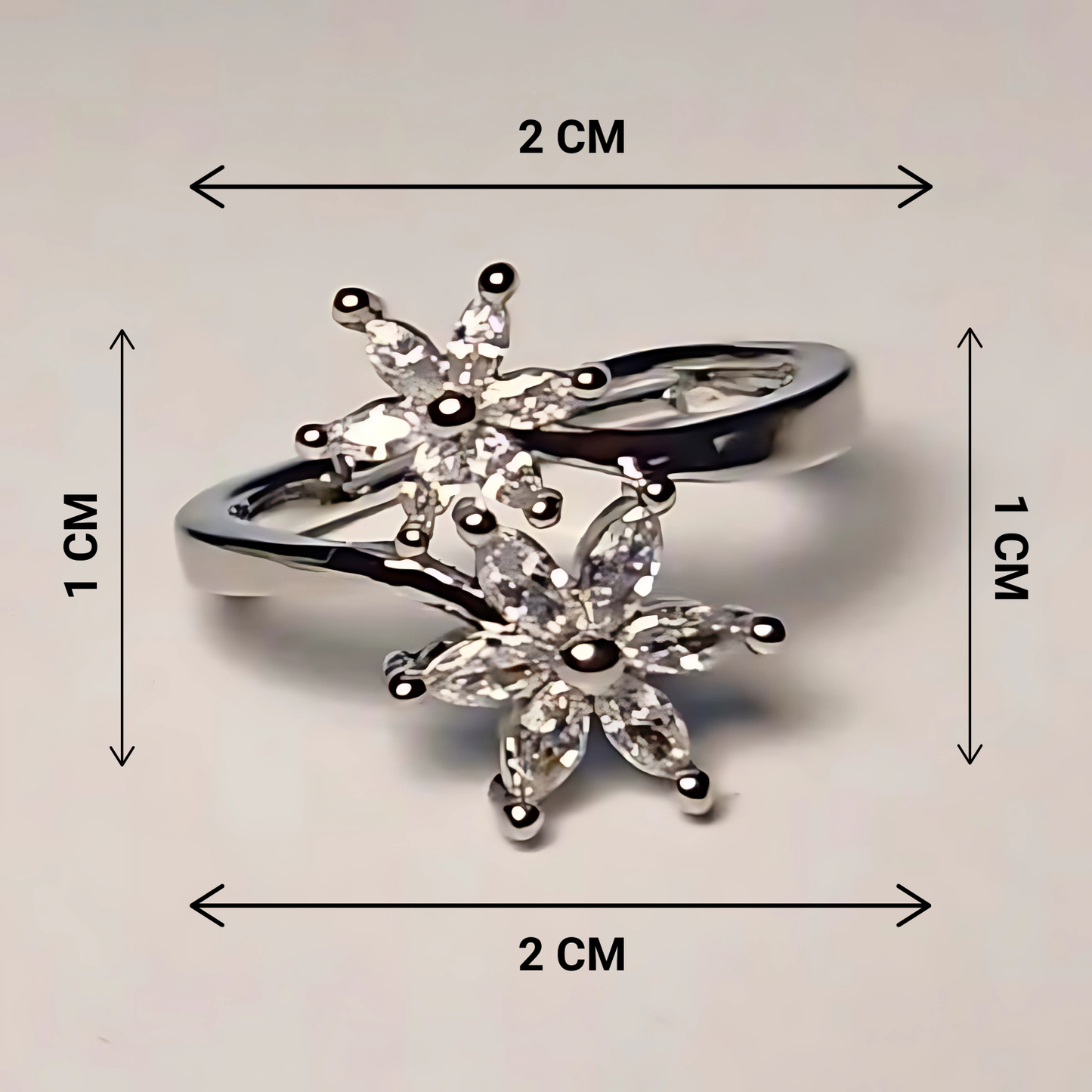 Silver ring with floral design and measurements on a light gray background