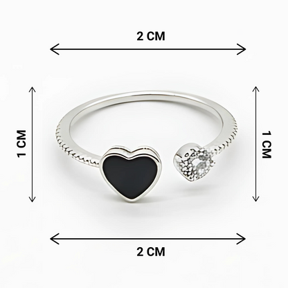 Silver ring with heart-shaped black and clear gemstones, shown with measurements on a white background.