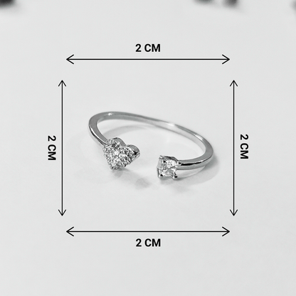 Silver ring with heart-shaped gemstones and measurement markings on a light gray background