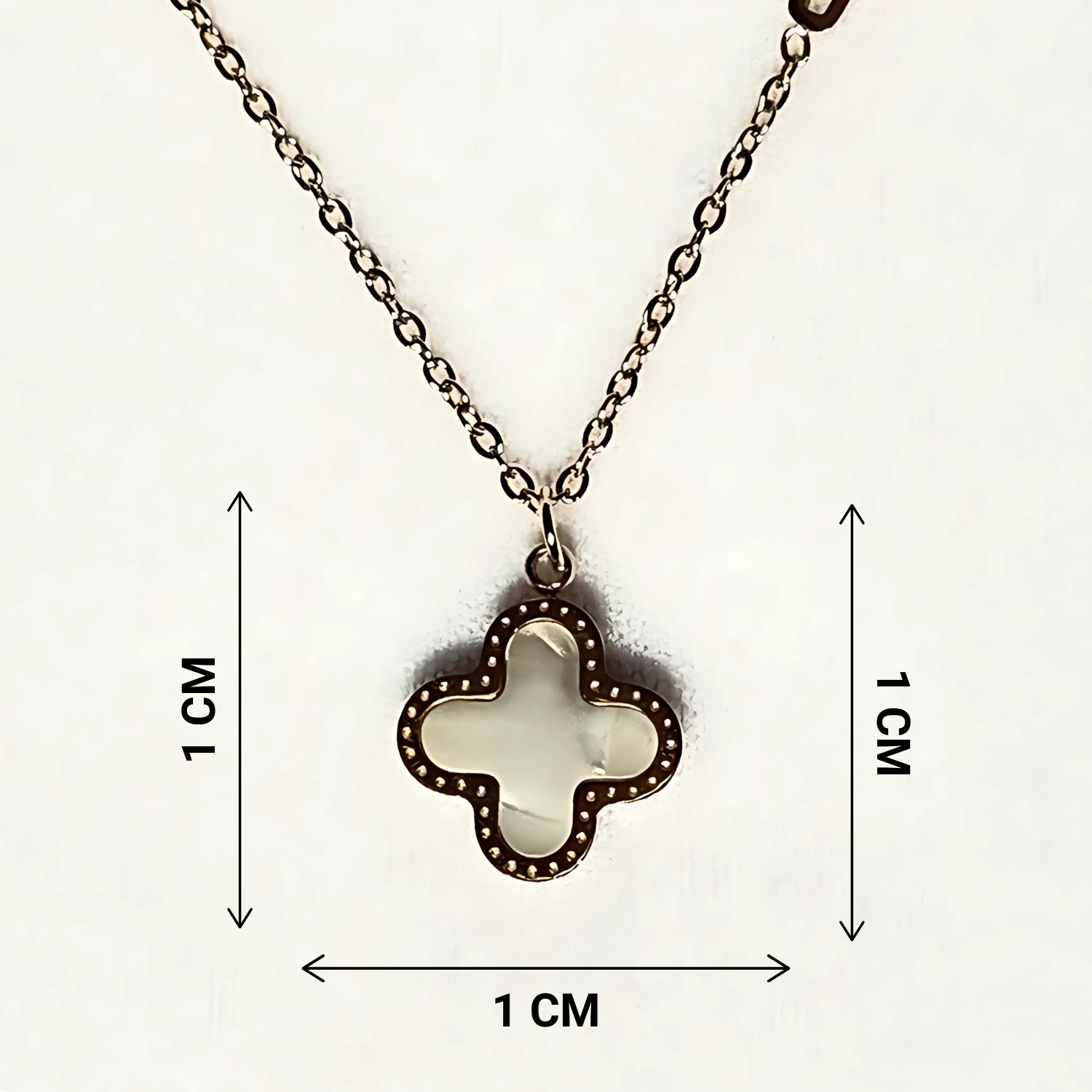 Clover-shaped pendant necklace with measurement markings on a white background