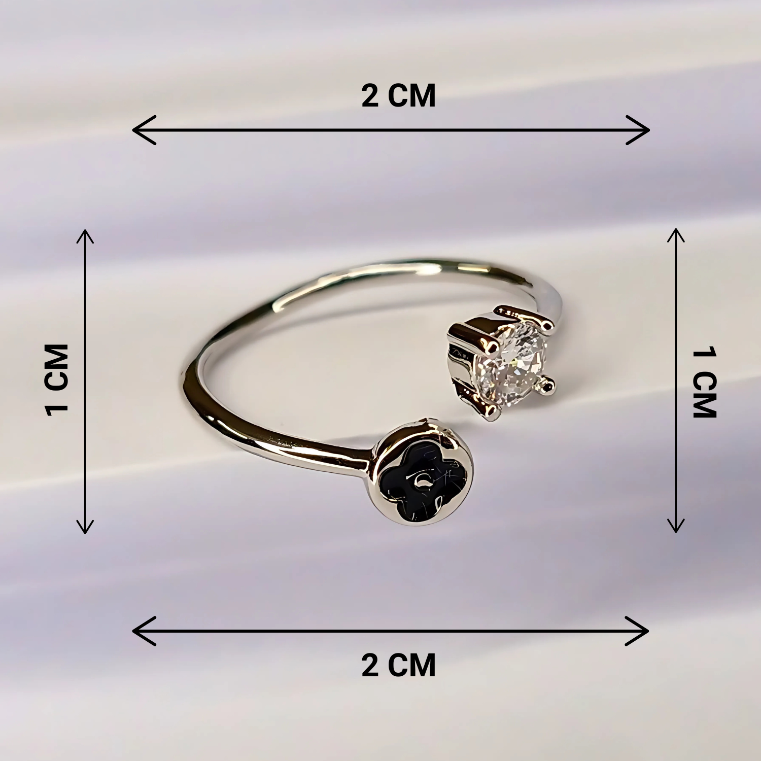 Gold earring with black flower design and clear gemstone, shown with measurements on a white background.