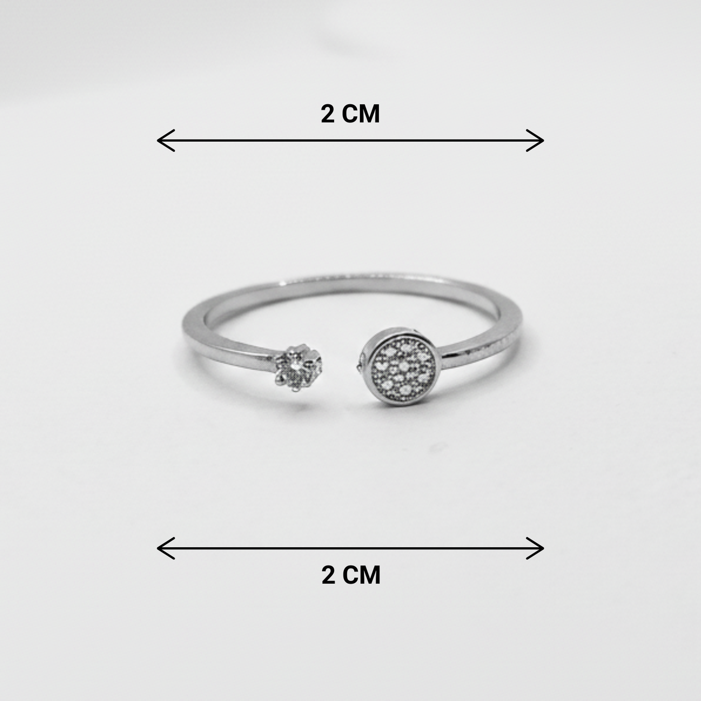 Silver ring with gemstones and measurement markings on a white background