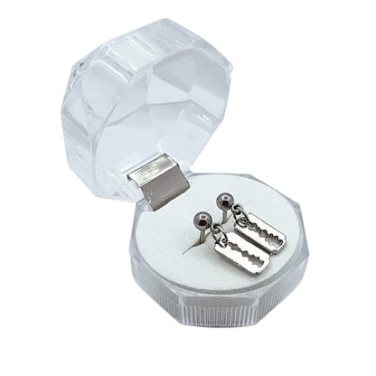 Silver earrings in a clear crystal box on a white background