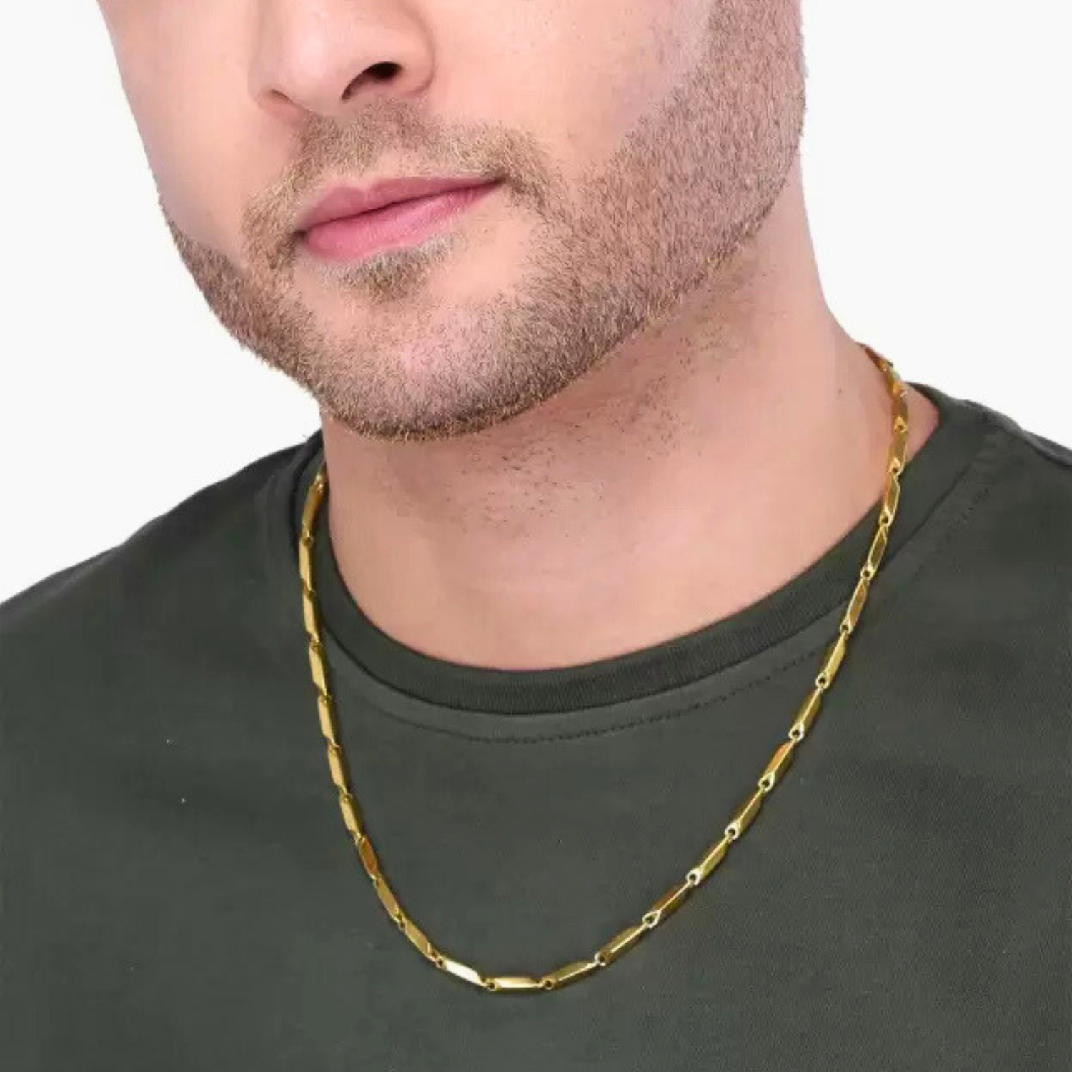 Man wearing a gold chain necklace on a plain background