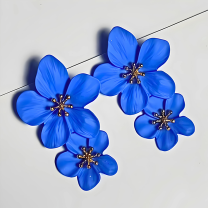 Blue flower-shaped earrings on a light gray background