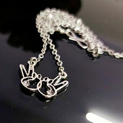 Silver necklace with a pendant on a reflective black surface