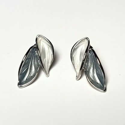 Pair of silver leaf-shaped earrings on a white background