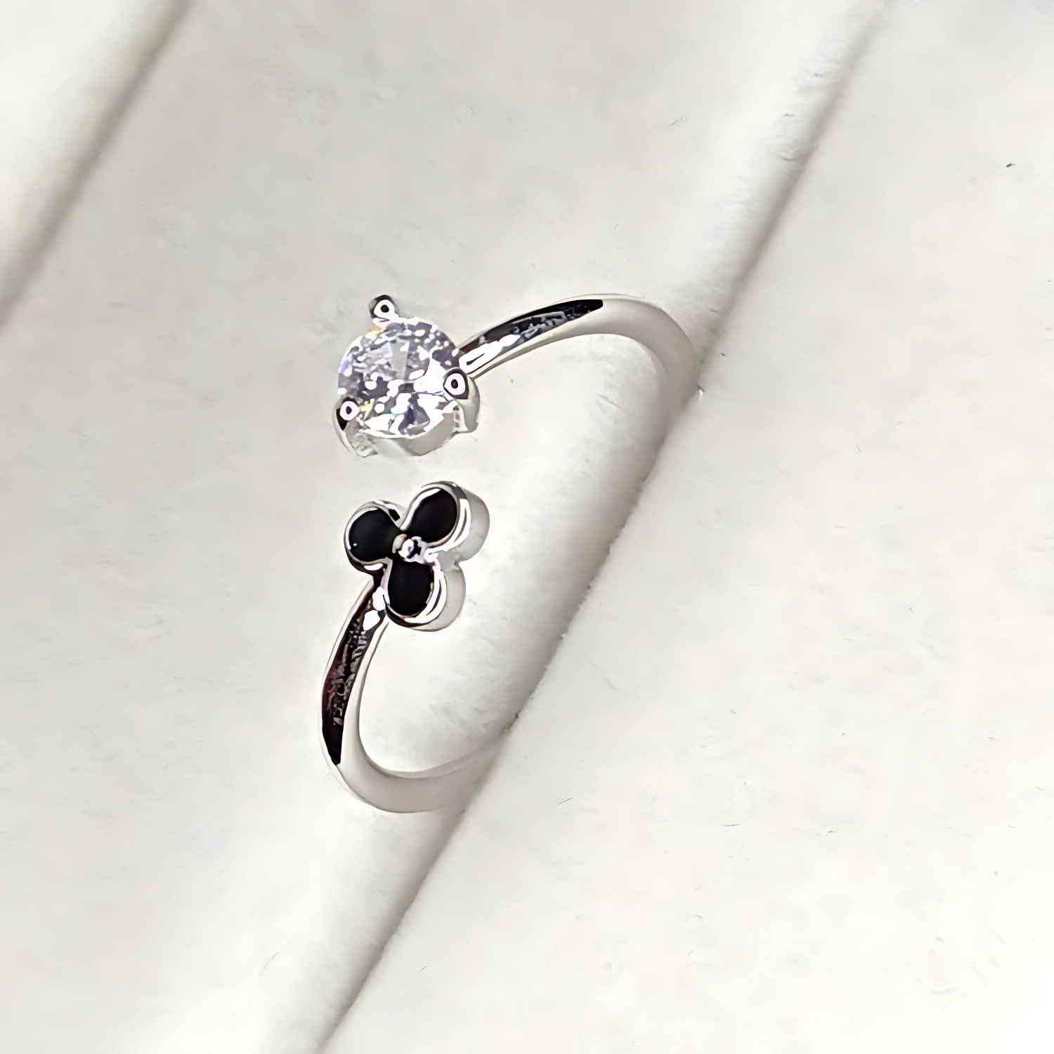 Silver ring with a flower design on a white background