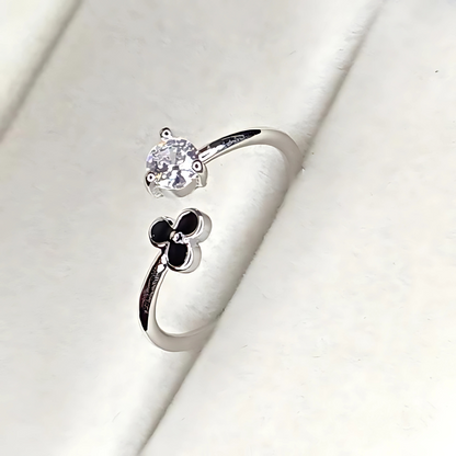 Silver ring with a flower design on a white background