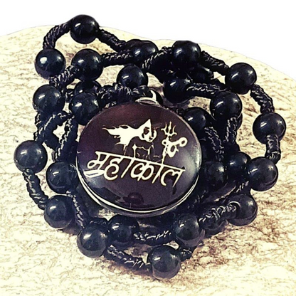 Black beaded necklace with a round black stone featuring white text and symbols on a beige background.