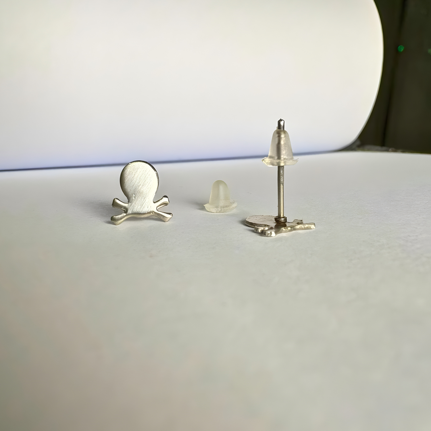 Three small metallic objects on a white surface with a blurred background
