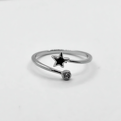 Silver ring with a star-shaped pendant on a light gray background