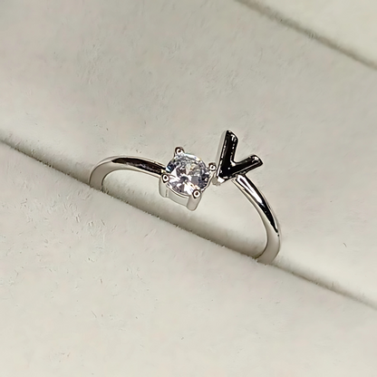 Silver ring with a diamond and black arrow design on a light gray background