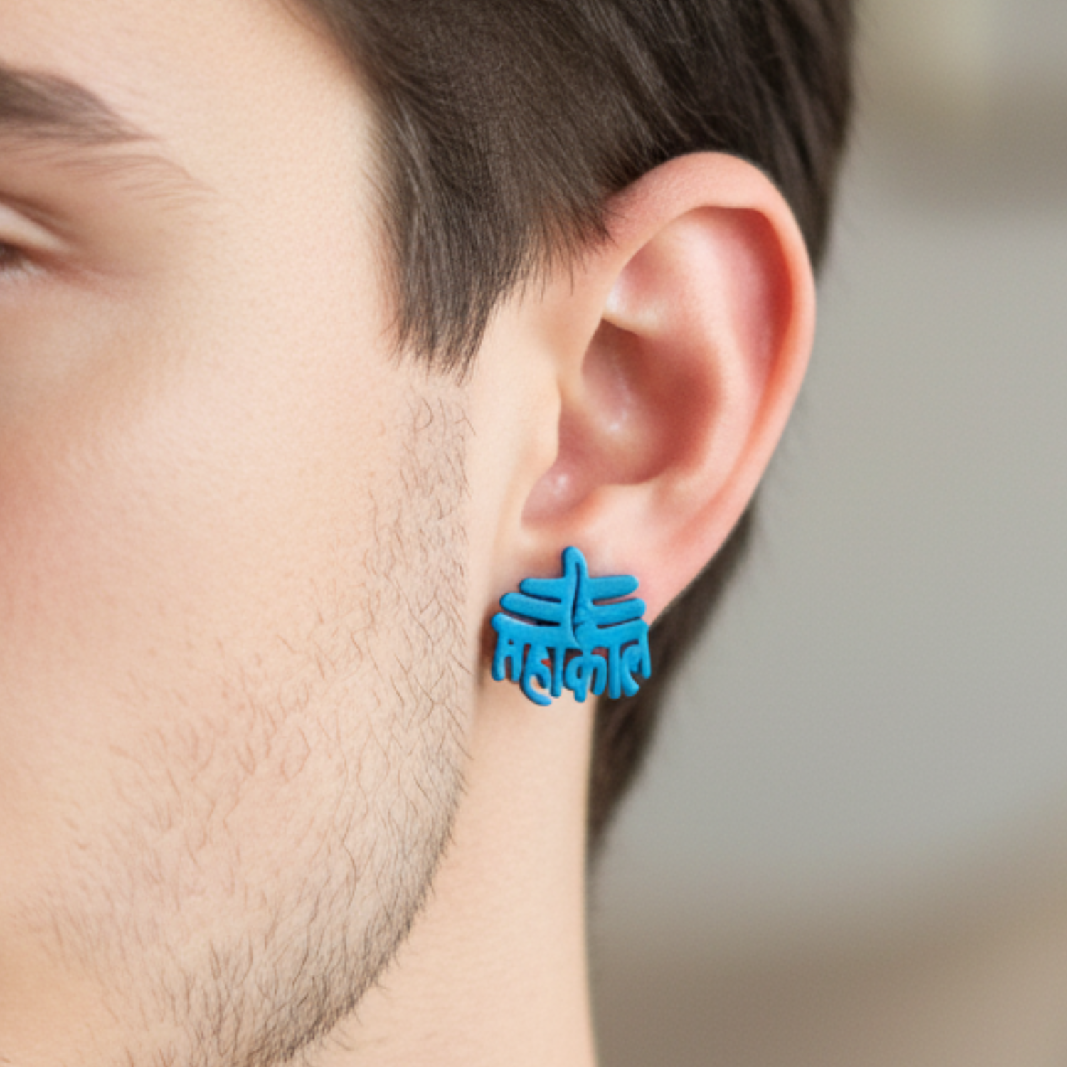 Blue earrings worn by a person with a blurred background