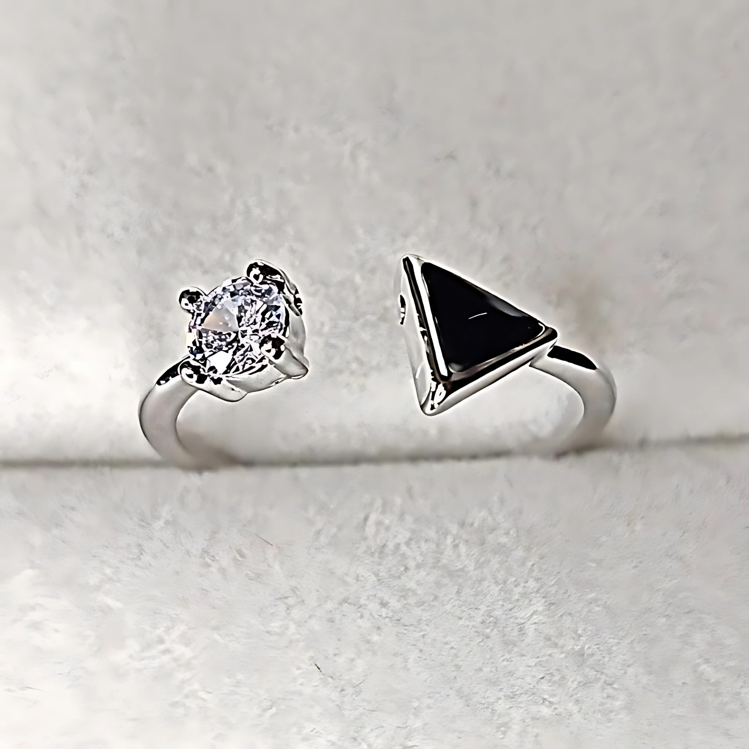 Two silver rings with gemstones on a light gray background