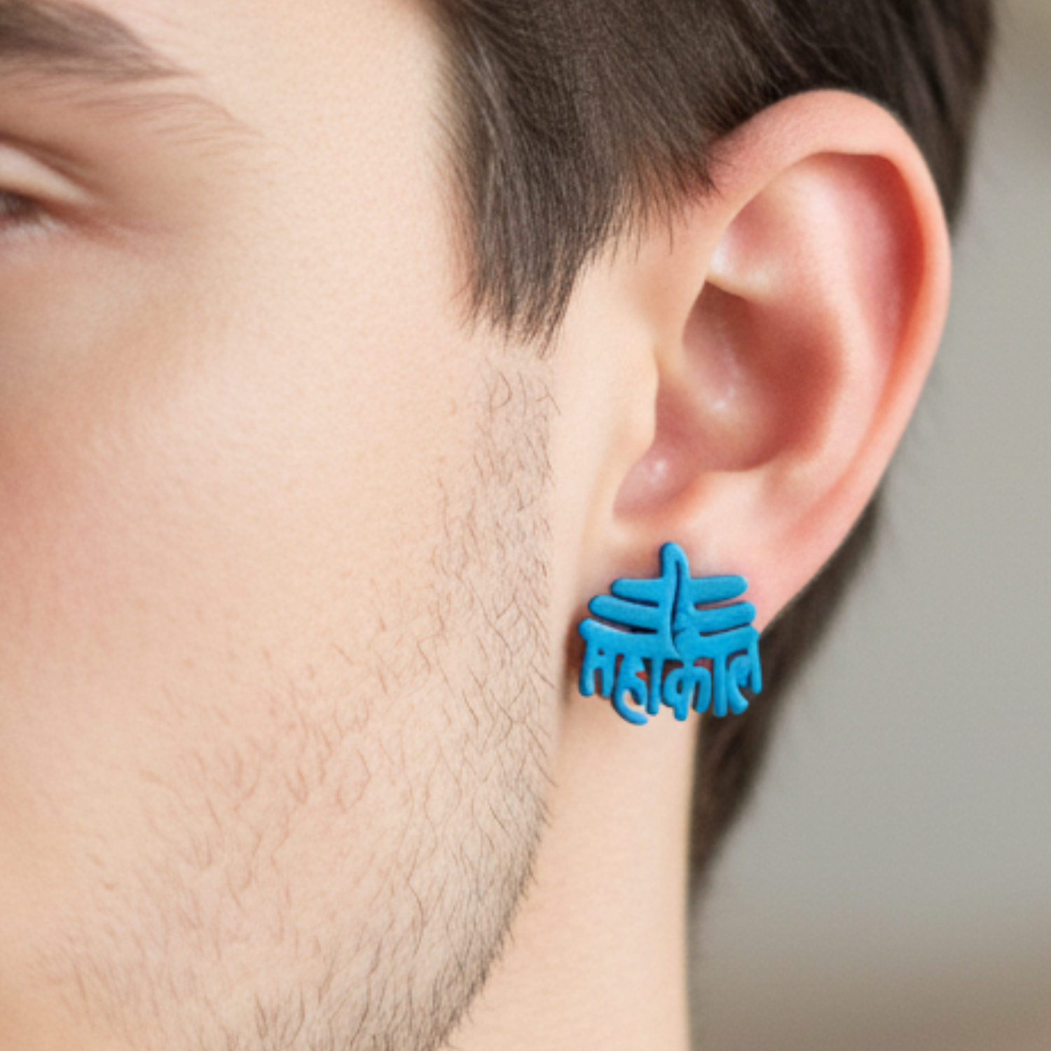 Blue earrings worn by a person with a neutral background