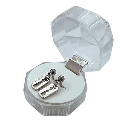 Silver earrings in a hexagonal crystal jewelry box on a white background