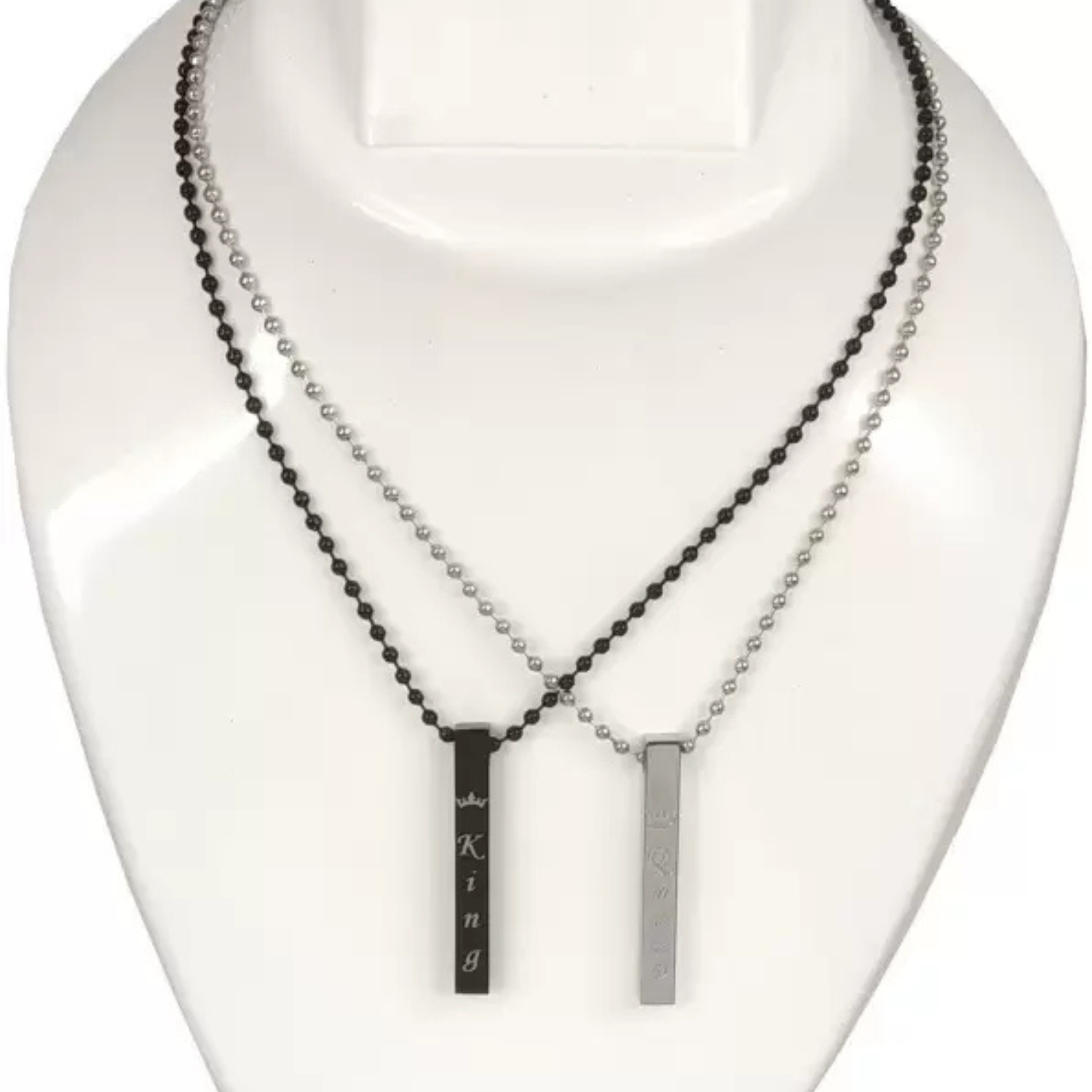 Two necklaces on a mannequin bust, one with black beads and the other with a silver bar pendant.