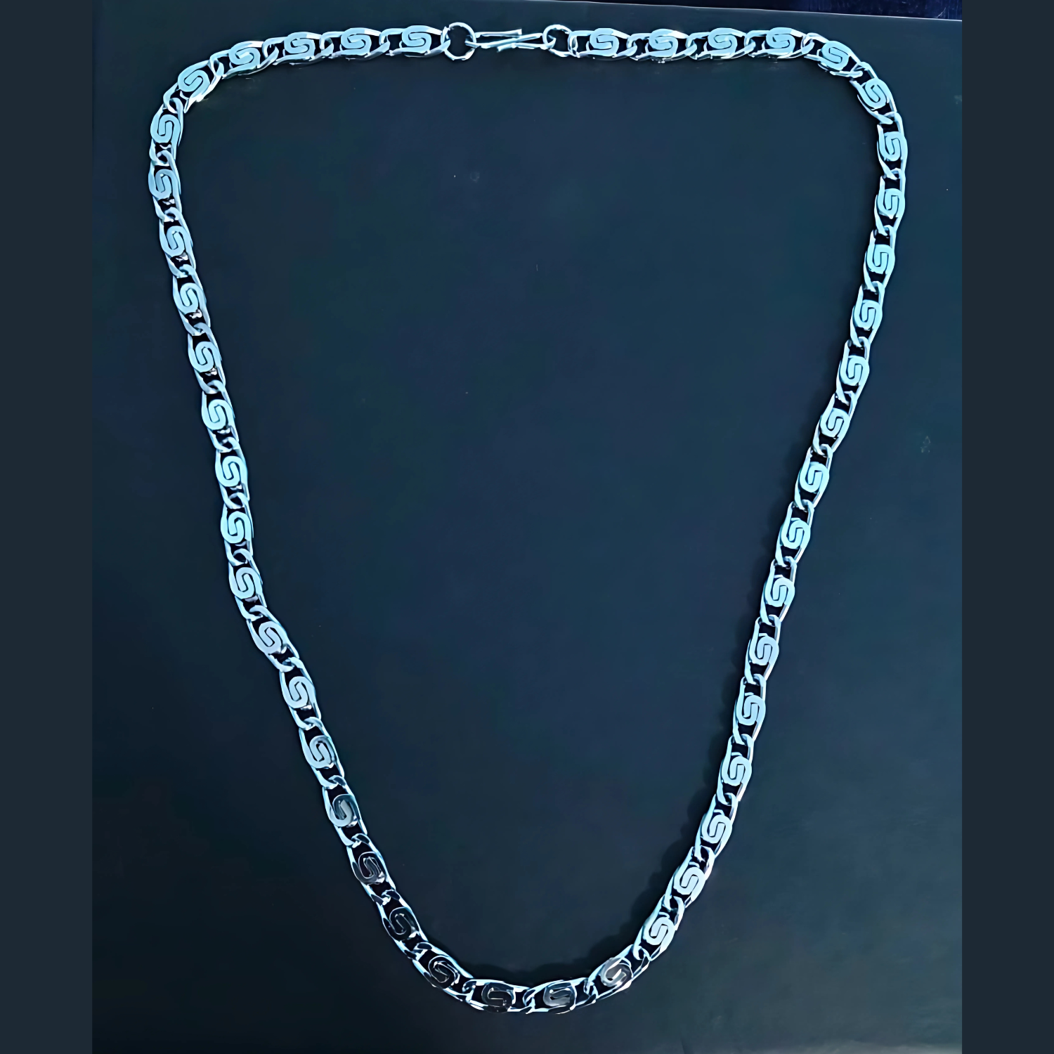 Silver chain necklace on a dark background
