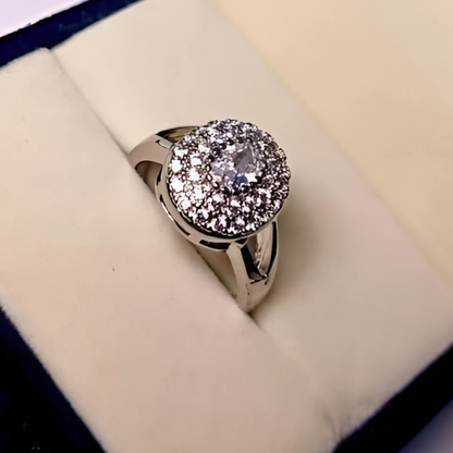 Silver ring with a large diamond on a cushioned surface